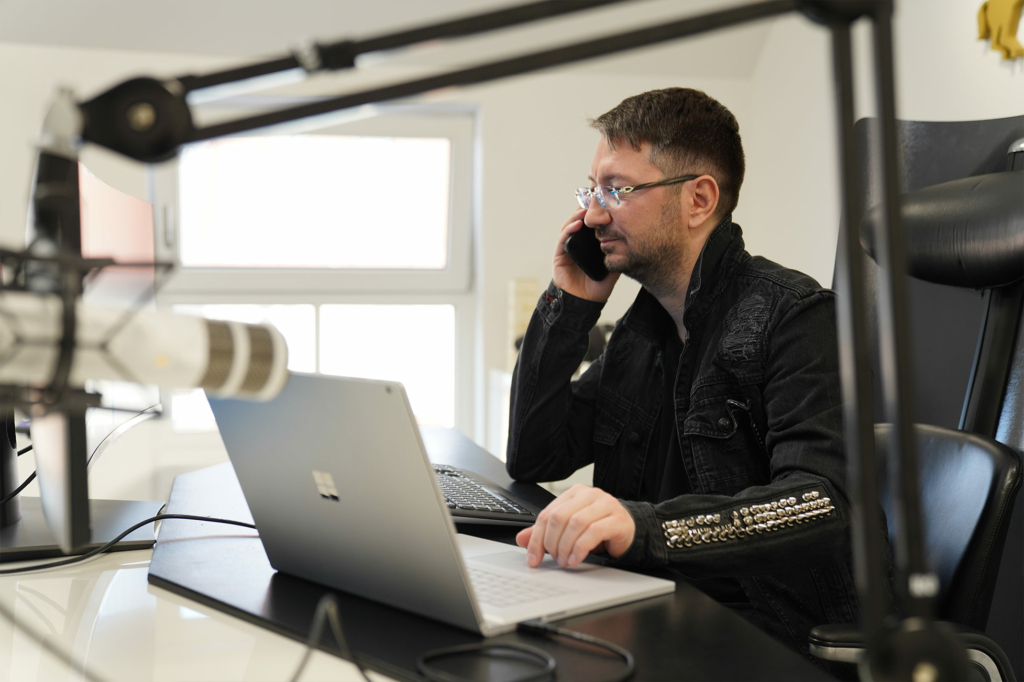 Walter Temmer Wahrheit Walter Temmer sitzt im Büro und hat ein Handy in seiner Hand. Mit der anderen hand tippt er auf ein Notebook