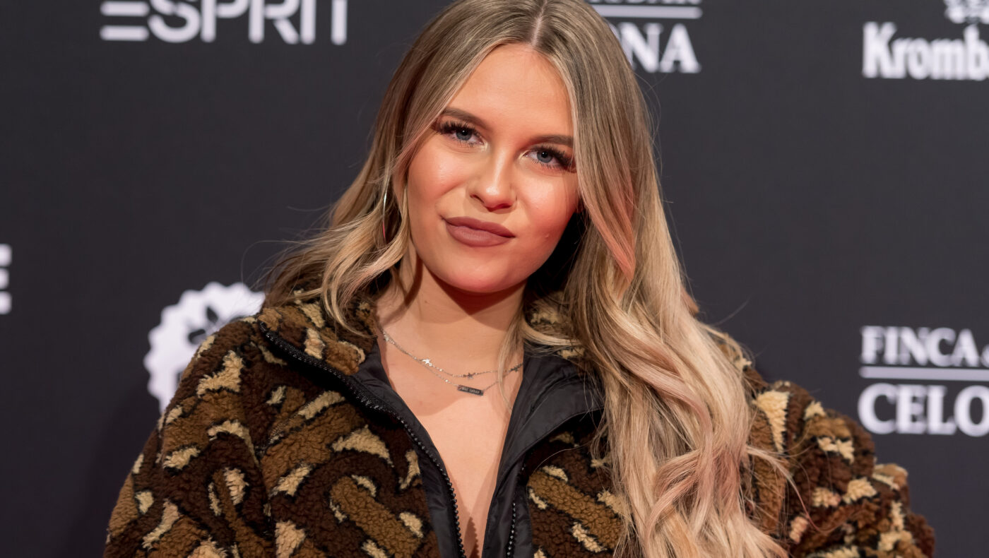 Dagi Bee posiert vor einer Werbewand