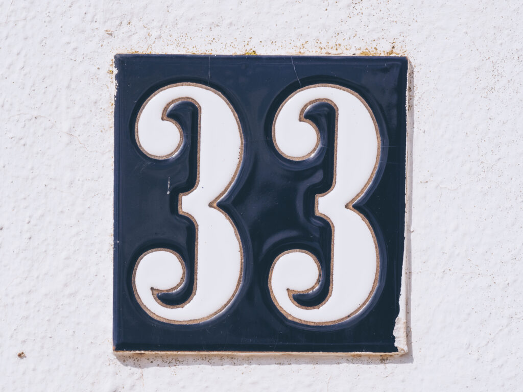 Nahaufnahme eines Hauszeichens mit der Nummer 33.