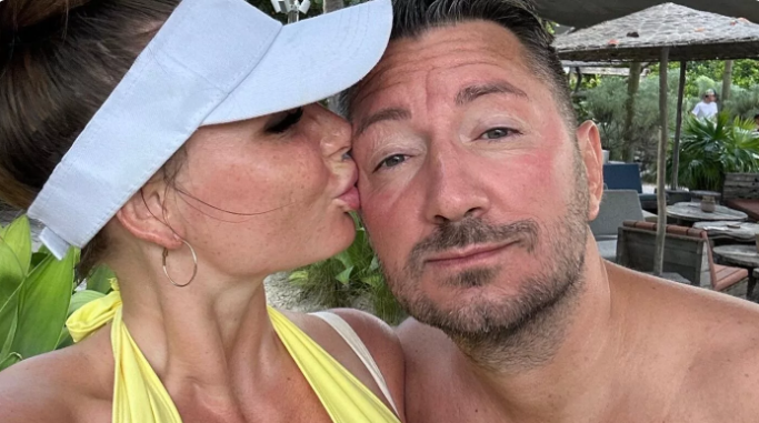 Susi und Walter Temmer in Nahaufnahme. Susi mit weißem Cap küsst Walter auf die Wange