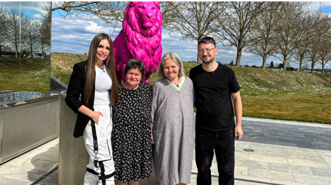 Susi und Walter Temmer stehen mit zwei Dame vor der Skulptur eines pinken Löwens und lachen in die Kamera