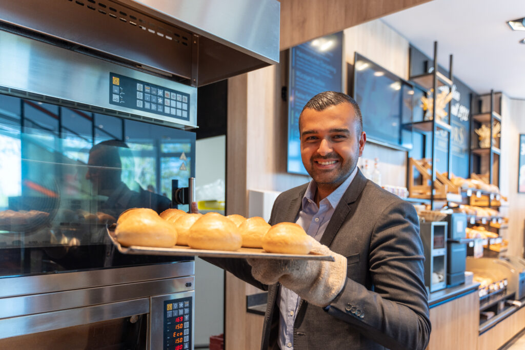 Eyüp Aramaz hält Backbleck mit Brötchen in den Händen