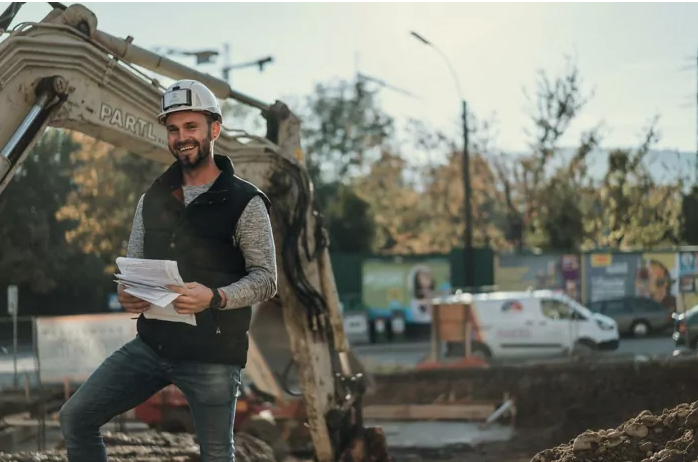 Bautechniker von Partl Bau Leibnitz Bautechniker von Partl Bau steht auf einer Baustelle in Leibnitz und hält Unterlagen in der Hand. Dahinter ist ein Baukran von Partl Bau zu sehen