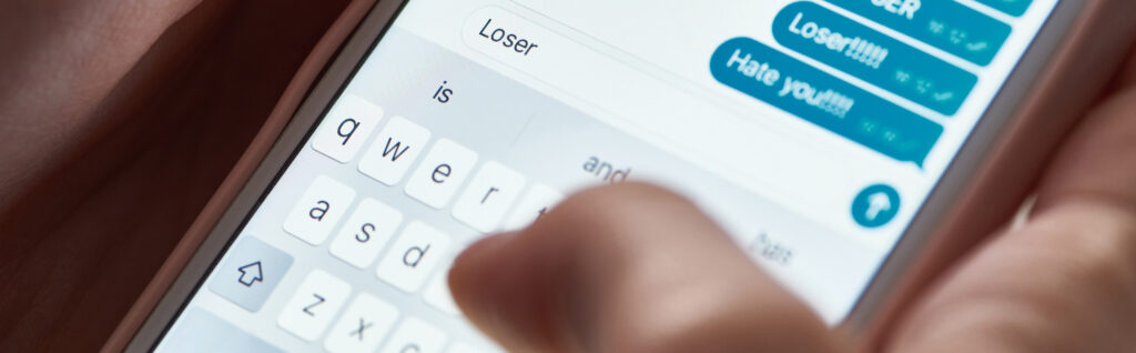 Person schreibt Hassnachrichten mit dem Handy