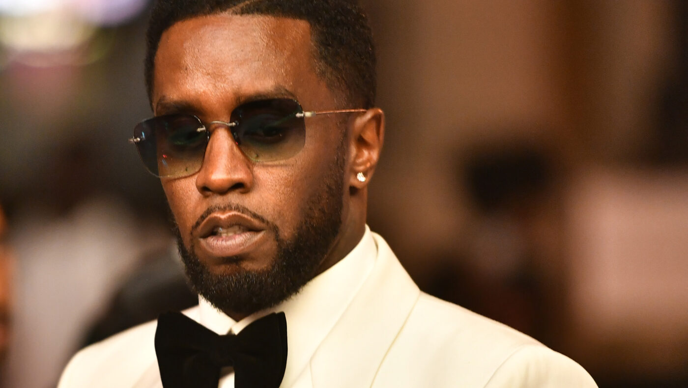 Diddy mit weißem Sakko und schwarzer Fliege sowie dunkler Sonnenbrille