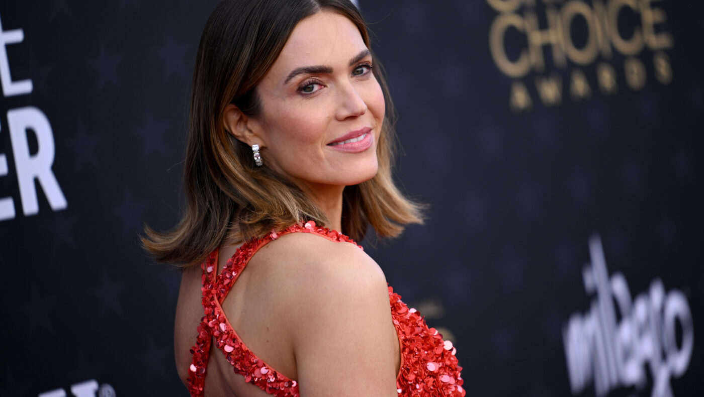 Mandy Moore mit rotem Kleid blickt über ihre Schulter in die Kamera
