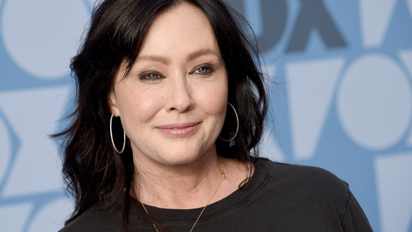 Shannen Doherty mit schwarzem Oberteil lächelt in die Kamera