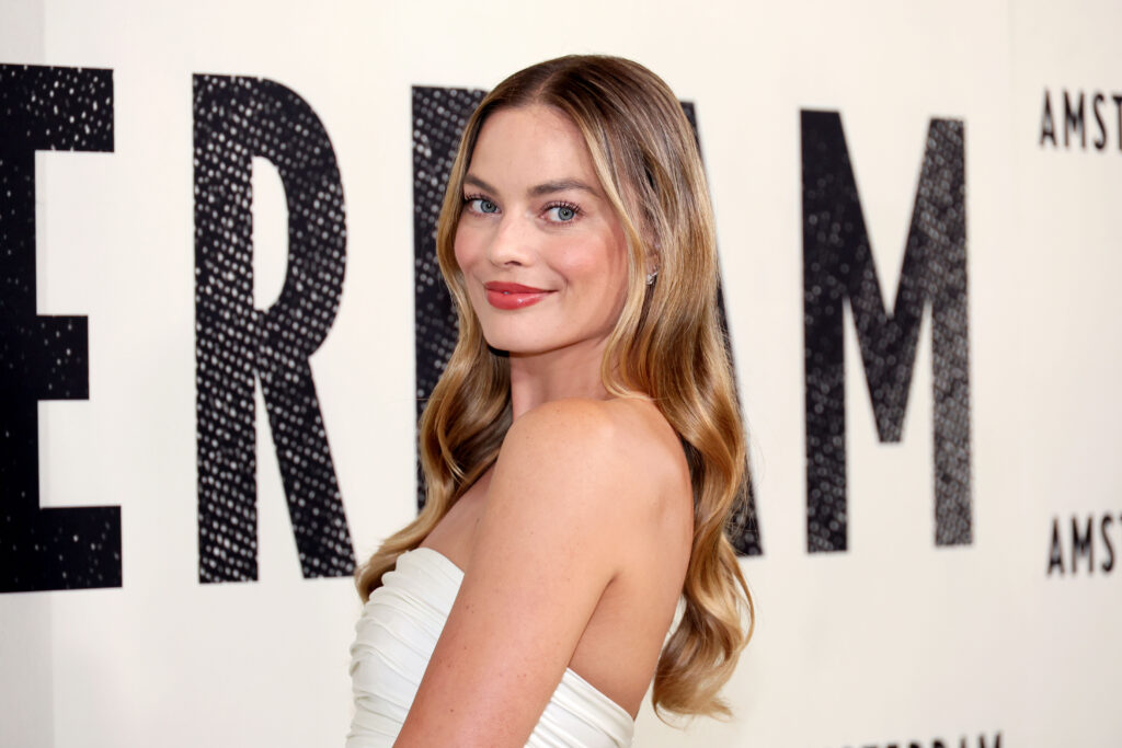 Margot Robbie posiert vor Werbewand