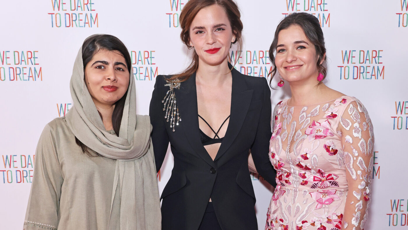 Emma Watson mit einem schwarzem Kleid steht mit zwei anderen Frauen zusammen