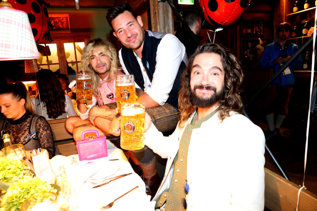 Bill Kaulitz, Tom Kaulitz und Marc Eggers halten Krug Bier in der Hand