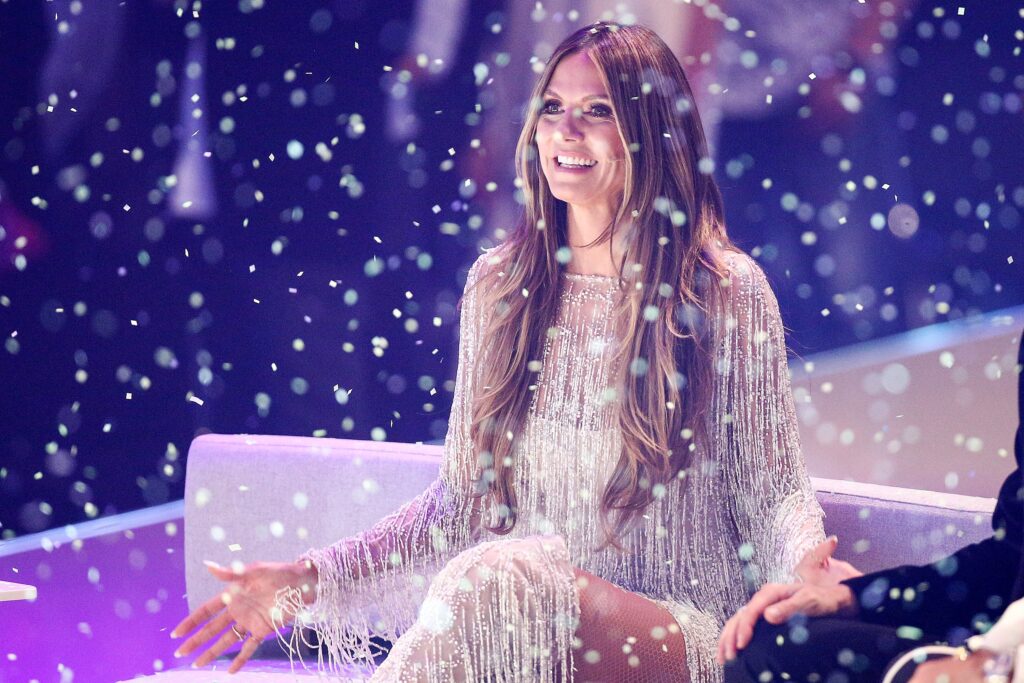 Heidi Klum mit Kleid aus Schnüren wird von kleinen Lichtern bestrahlt