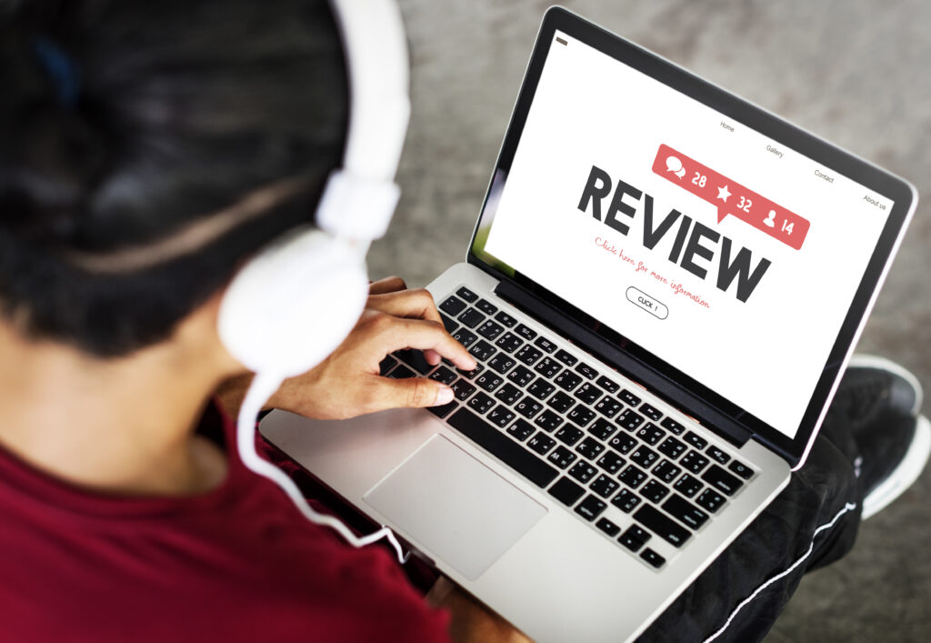 Computer mit Review Seite geöffnet und ein Mensch mit Headset davor