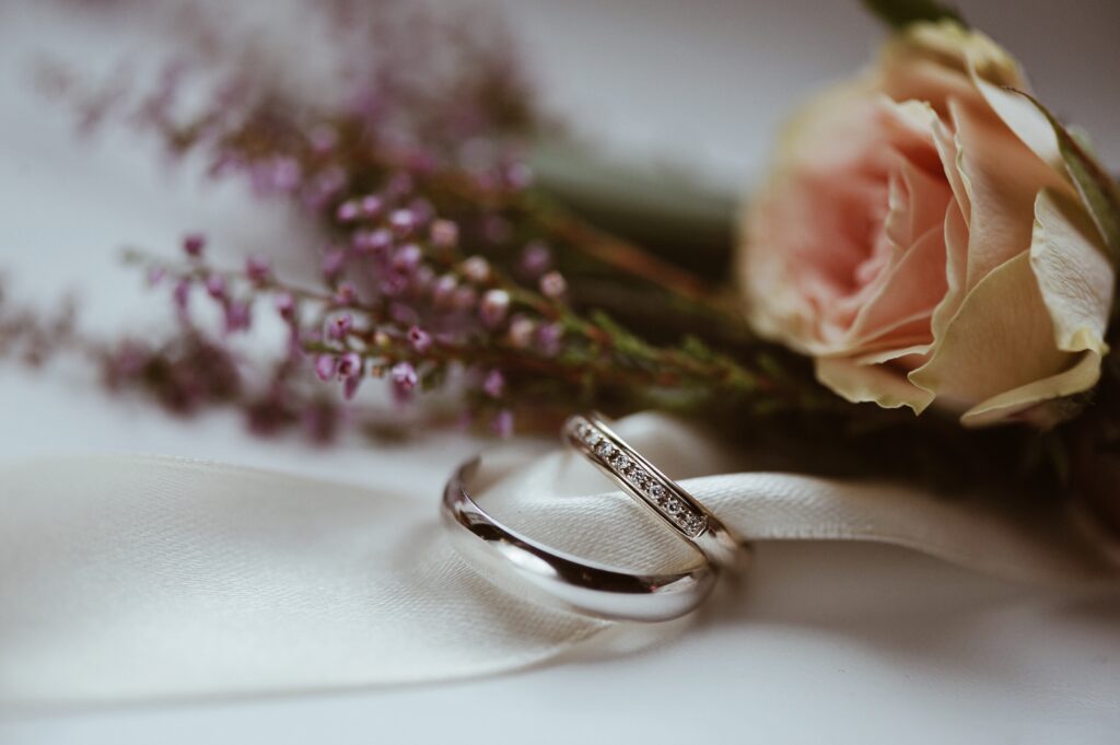 Hochzeitsringe und eine Rose in Nahaufnahme