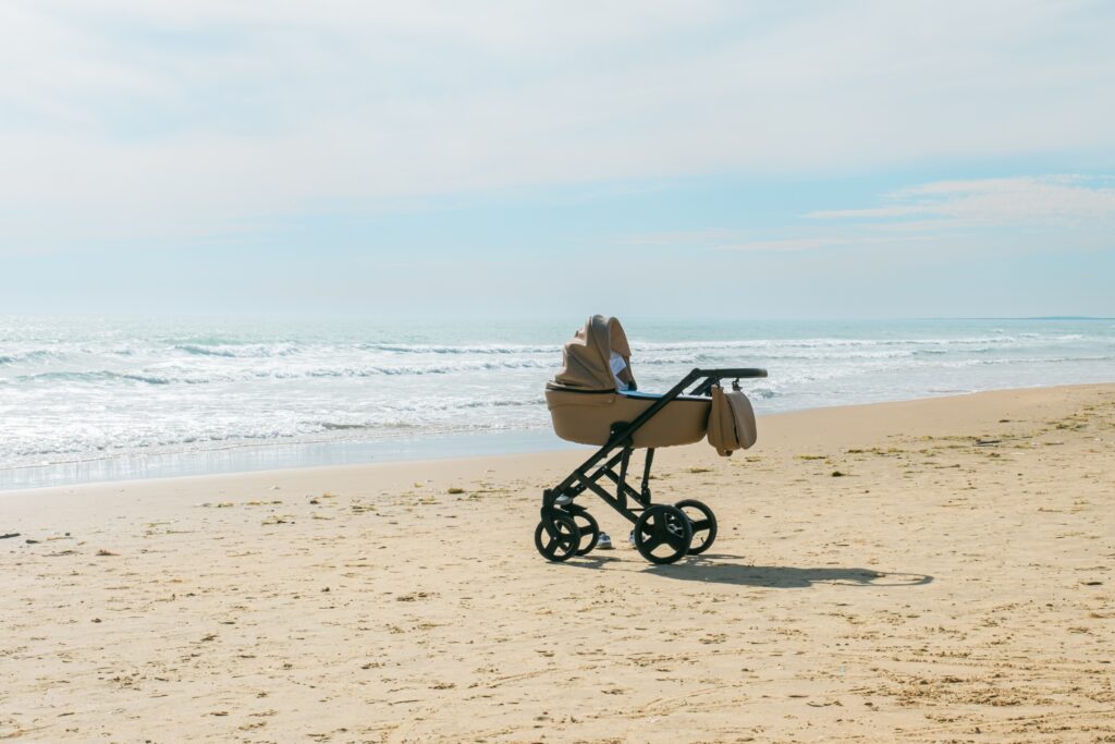Kinderwagen in beige der an einem Strand steht