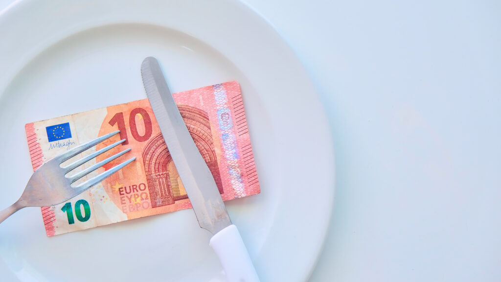 Euro-Banknote auf einem weißen Teller, Bargeld in Europa, die Kosten für das Mittagessen im Restaurant
