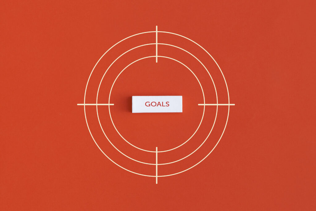 oranger Hintergrund mit Zielscheibe und Goals in der Mitte