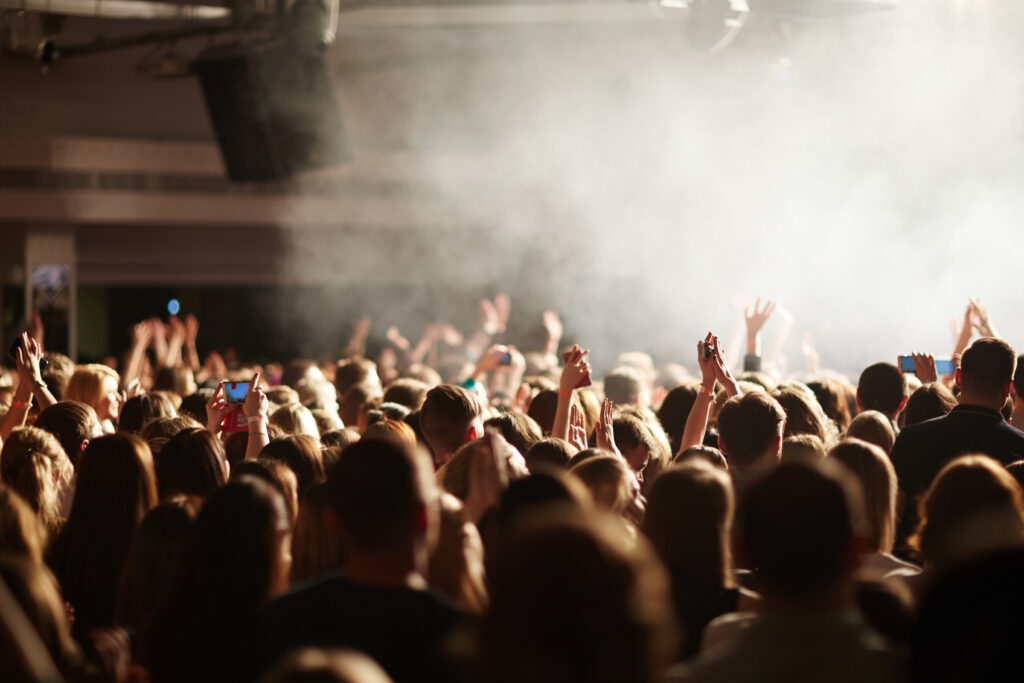 Viele Menschen bei einem Konzert die teilweise ihre Handys und Hände in die Höhe heben