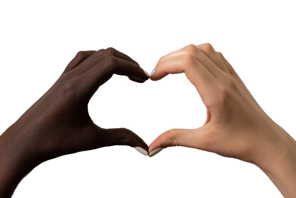 weiße und schwarze Hand formen gemeinsam ein Herz