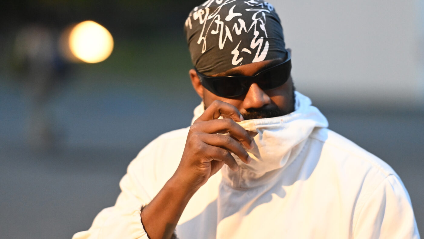 Kayne West mit weißem Pullover und Cap